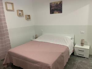 una camera bianca con un letto e una foto appesa al muro di Welcome Milano Guest House a Milano