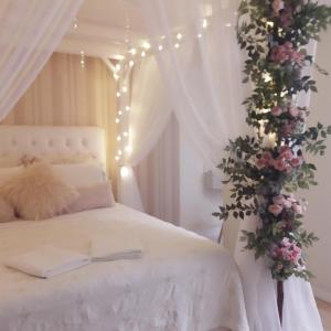 a bedroom with a white bed with flowers and lights at Live House Boutique Hotels in Sao Paulo