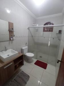 uma casa de banho com um chuveiro, um WC e um lavatório. em Sitio Morada da Felicidade em Esmeraldas