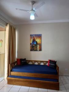 a bed in a room with a ceiling fan at Apartamento da Martha in Ubatuba +8 photos