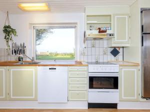 une cuisine avec des placards blancs et une fenêtre dans l'établissement Holiday home Karby II, à Karby