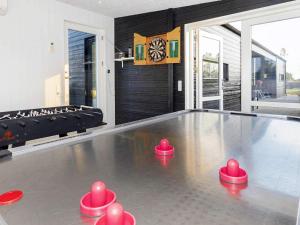 mesa de ping pong en la sala de estar con pelotas de ping pong rosas en 8 person holiday home in L gstrup en Løgstrup