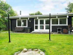 a black house with a lawn in front of it at Holiday home Vig XLIII in Vig