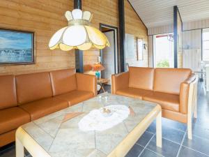ein Wohnzimmer mit Sofas, einem Tisch und einem Kronleuchter in der Unterkunft 8 person holiday home in Vinderup in Vinderup