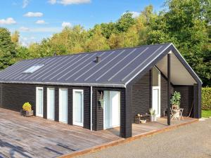 a black shed with a wooden deck at 4 star holiday home in Skals-By Traum in Skals