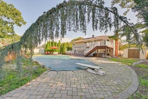 a backyard with a stone driveway and a house at New York Abode with Pool and Patio, Near Times Square! in Islip Terrace