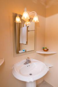 y baño con lavabo blanco y espejo. en Franklyn D Resort & Spa All Inclusive en Runaway Bay