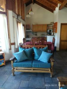 un sofá azul en una sala de estar con cocina en ABROJITOS en Villa La Angostura
