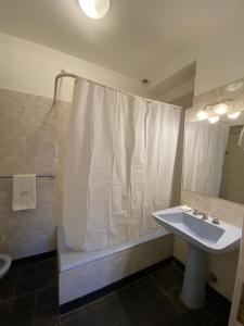 a bathroom with a tub and a sink and a shower at Hotel California in Mar del Plata