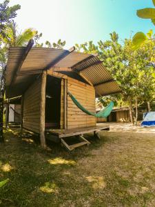 a house with a hammock in front of it at Camping Atobá Praia do Sono in Paraty