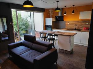 a living room with a couch and a kitchen at Le pigeonnier in Millau