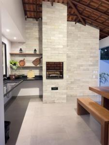 a kitchen with a stone wall with a fireplace at Alter do Chão - Alter Casa Cocar in Alter do Chao