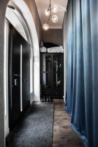 un pasillo con una puerta negra y una cortina azul en Spacious Oasis only Minutes From the City Center, en Estocolmo