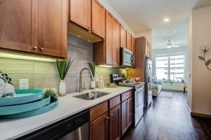 a kitchen with wooden cabinets and a sink at Best 5* Luxury Living Downtown kingbed Suite in Houston