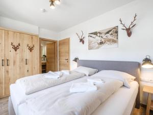 1 dormitorio con 1 cama blanca grande con almohadas blancas en Tauernsuites Sonnblick Top 5, en Mühlbach am Hochkönig