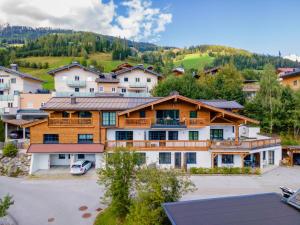 a large house with a car parked in a parking lot at Tauernsuites Sonnblick Top 5 in Mühlbach am Hochkönig