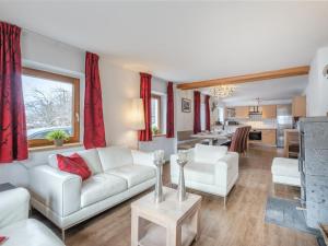 a living room with white furniture and a kitchen at Kitzbüheler Alpen XL in Bramberg am Wildkogel