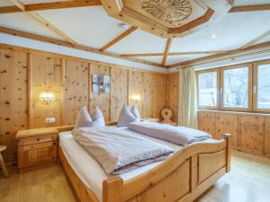 a bedroom with a large bed in a room with wooden walls at Kitzbüheler Alpen XL in Bramberg am Wildkogel