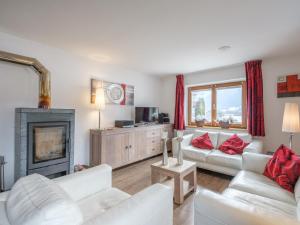 a living room with white furniture and a fireplace at Kitzbüheler Alpen XL in Bramberg am Wildkogel