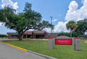 un panneau qui lit ramana devant un bâtiment dans l'établissement Ramada by Wyndham Gulfport I-10 Diamondhead, à Diamondhead