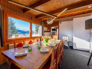 a dining room with a long wooden table and chairs at Chalet H Königsleiten in Königsleiten