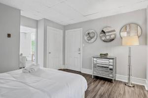 a white bedroom with a bed and a lamp at Midtown 1BR: Downtown HBG Hub in Harrisburg