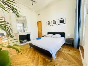 um quarto com uma cama branca e uma planta em Haussmannien lumineux em Marselha