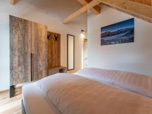 a bedroom with a large bed and a wooden wall at Mountain Chalet Dahoam in Sankt Lorenzen ob Murau