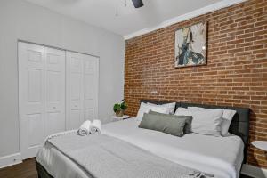 1 dormitorio con 1 cama grande y pared de ladrillo en HBG 1BR: Modern Vintage Gem en Harrisburg