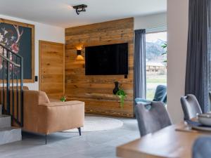 a living room with a television on a wooden wall at Bergzicht 2B in Sankt Lorenzen ob Murau