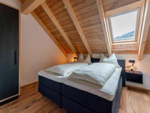 un grande letto in una stanza con una grande finestra di Bergzicht 2B a Sankt Lorenzen ob Murau