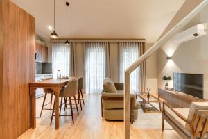 Il comprend une cuisine et un salon avec une table et un canapé. dans l'établissement AVUS M Suites and Apartments by DA'HOME, à Porto