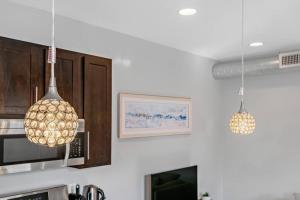 a kitchen with two pendant lights hanging from the ceiling at Charming HBG Haven: Cozy 1BR Apt in Harrisburg