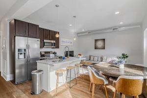 a kitchen with a table and a stainless steel refrigerator at Charming HBG Haven: Cozy 1BR Apt in Harrisburg