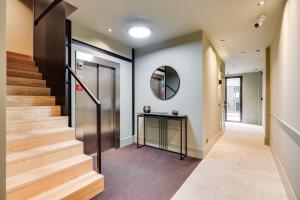 een hal met een trap en een spiegel bij AVUS M Suites and Apartments by DA'HOME in Porto