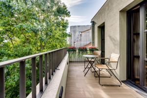 een balkon met 2 stoelen en een tafel bij AVUS M Suites and Apartments by DA'HOME in Porto