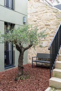 un arbre assis à côté d'un banc à côté d'un bâtiment dans l'établissement AVUS M Suites and Apartments by DA'HOME, à Porto