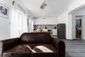 a leather couch in a living room with a kitchen at Pátio da Baixa in Setúbal