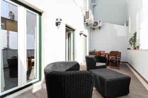 a living room with wicker chairs and a table at Pátio da Baixa in Setúbal