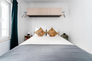 1 dormitorio con 1 cama blanca grande y 2 almohadas en Pátio da Baixa en Setúbal