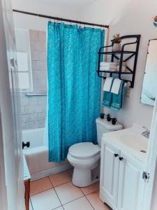 La salle de bains est pourvue de toilettes et d'un rideau de douche bleu. dans l'établissement *Free Parking near Strip Cozy 2Br home Side: A, à Las Vegas
