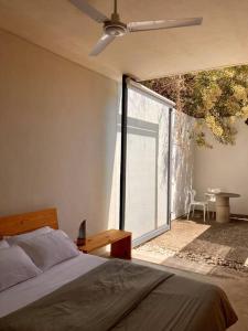 a bedroom with a bed and a large window at Casa Meztitla in Tepoztlán