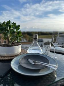 einen Tisch mit einem Teller und einem Glas Wein in der Unterkunft Oasis Appart - Wohnen am Elbtal - Balkon - Netflix - Tiefgarage in Dresden