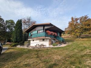 a house with a balcony and a picnic table in front of it at Chalet rénové proche du Valtin – Idéal pour famille, randonnées et ski, Wifi, luges fournies - FR-1-589-150 in Ban-sur-Meurthe-Clefcy