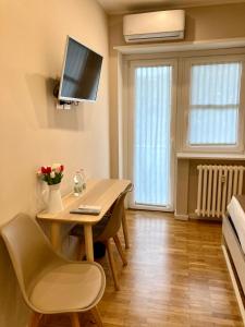 a dining room with a table and a tv on the wall at Maison Altinia in Treviso