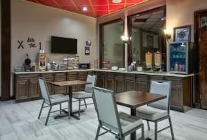 un restaurant avec une table et des chaises ainsi qu'un bar dans l'établissement Ramada by Wyndham Gulfport I-10 Diamondhead, à Diamondhead