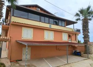 a large orange house with a palm tree at La Foggia seaside paradise in Siculiana