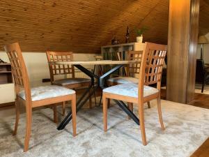 a dining room table with three chairs and a table at Apartments with a parking space Sveta Nedelja, Prigorje - 21835 in Strmec Samoborski