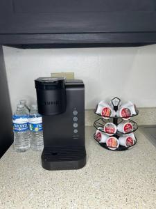 a coffee maker sitting on a counter next to some cupcakes at 1 BR Loft Medical District Fondren in Jackson