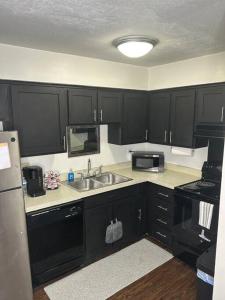 a kitchen with black cabinets and a sink and a microwave at 1 BR Loft Medical District Fondren in Jackson